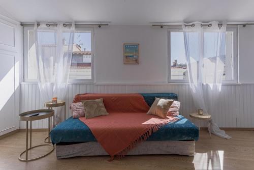 a room with a couch and two windows at Studio André - Palais & plage, clim in Cannes