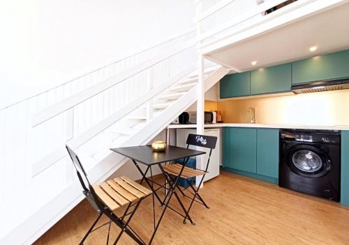 a kitchen with a table and chairs and a staircase at Studio André - Palais & plage, clim in Cannes