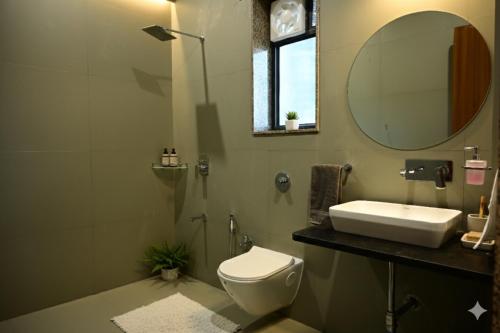 a bathroom with a sink and a toilet and a mirror at Achal Bagh - Boutique Stay Abu Road in Māwāl
