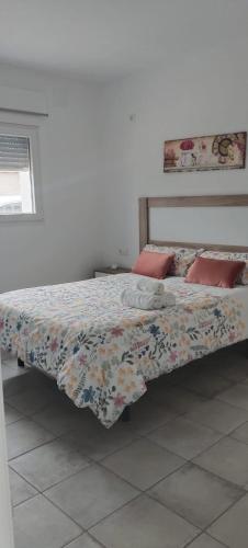 a bedroom with a bed with a floral comforter at AR El ENCÍN TR-CC-00592 in Valdencin