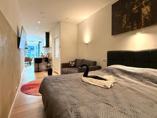 a bedroom with a bed and a living room at Stylish studio in the heart of Breda city center in Breda