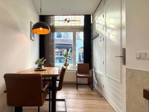 a dining room with a table and chairs and a window at Stylish studio in the heart of Breda city center in Breda