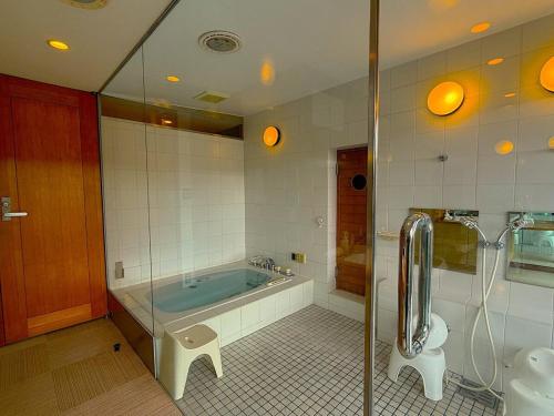 a bathroom with a tub and a toilet at 熱海ブレスアネックス in Atami