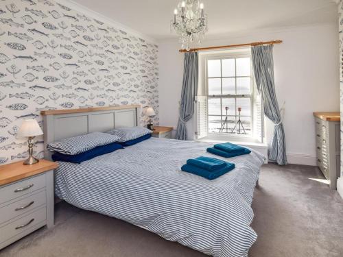 a bedroom with a bed with blue pillows on it at 4 Bed in Bideford oc-incot in Instow