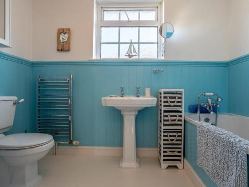 a bathroom with a sink and a toilet and a window at 4 Bed in Bideford oc-incot in Instow
