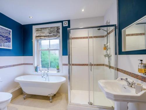a bathroom with a tub and a shower and a sink at 4 Bed in Harrogate oc-73424 in Harrogate