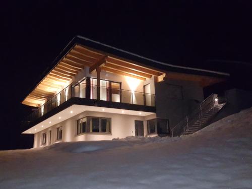 Una casa de noche con nieve delante en Apart La Vita, en Kappl