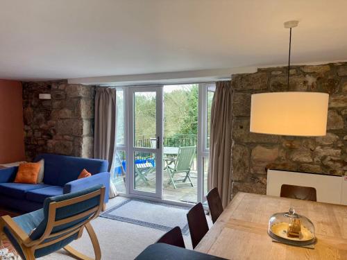 a living room with a blue couch and a table at Saddle Cottage in Penzance