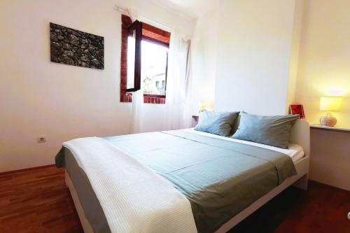 a bedroom with a large bed with a window at Apartment Terrarossa 2 in Fažana