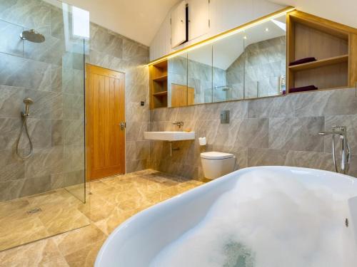 a bathroom with a tub and a toilet and a sink at 4 Bed in Braunton oc-62949 in Croyde