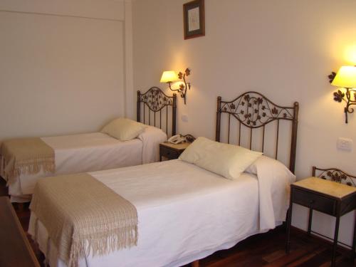 Una cama o camas en una habitación de Hotel Asturias
