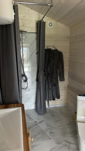 a bathroom with a shower and a shower curtain at Гойра in Dzembronya