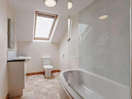 a bathroom with a tub and a toilet and a sink at 3 Bed in Bideford oc-05171 in Woolfardisworthy