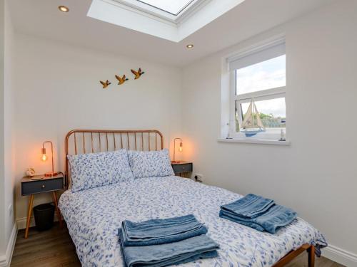a bedroom with a bed with blue sheets and a window at 2 Bed in Alnwick oc-78956 in Embleton