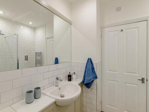 a white bathroom with a sink and a mirror at 2 Bed in Alnwick oc-78956 in Embleton