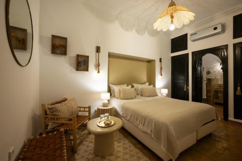 a bedroom with a bed and a table and a chair at Riad Dar Beldia and Spa in Marrakesh
