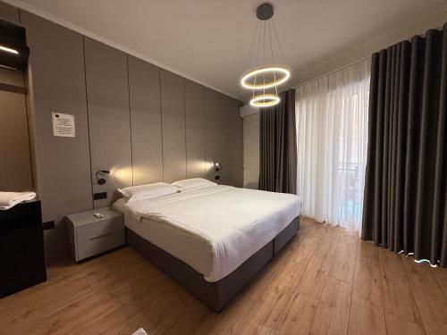 a bedroom with a large bed and a large window at Centralin Apartotel in Tirana