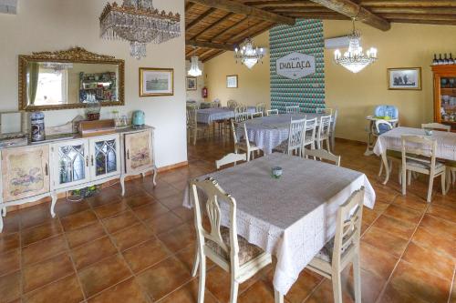 a dining room with tables and chairs and a mirror at Monte Chalaça - Turismo Rural in Ferreira do Alentejo