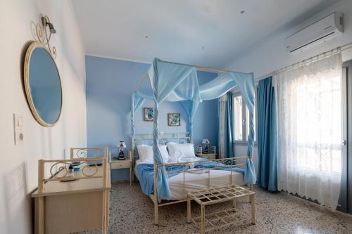 a blue bedroom with a bed with a canopy at Giasemi Rooms in Livadi Astypalaias