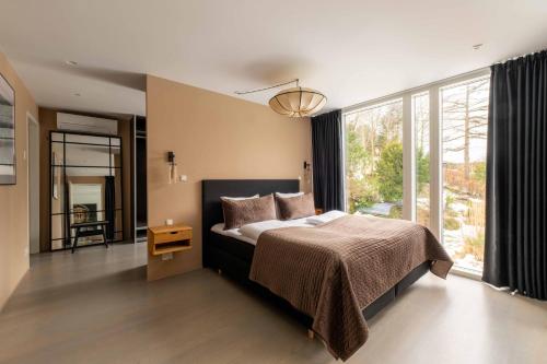 a bedroom with a bed and a large window at Exclusive Duplex Mansion with Sauna & Pool in Charlottenlund