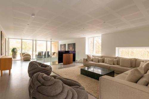 a living room with a couch and a table at Exclusive Duplex Mansion with Sauna & Pool in Charlottenlund