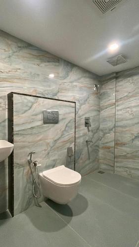 a bathroom with a toilet and a sink at Tresor Hotel in Cochin