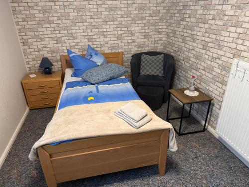 a small bedroom with a bed and a chair at Gästezimmer Neumann in Bad Münder am Deister