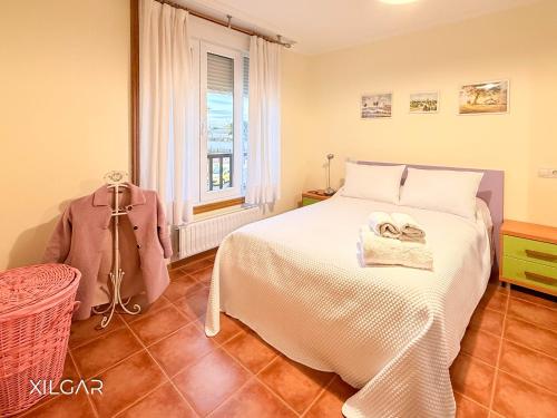 a bedroom with a white bed and a window at Xilgar - Chalet Ensenada de Lanzada in Sanxenxo