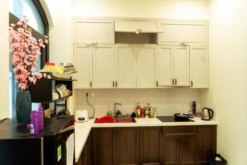 a kitchen with white cabinets and a sink at My Sweet House in Hòa Bình