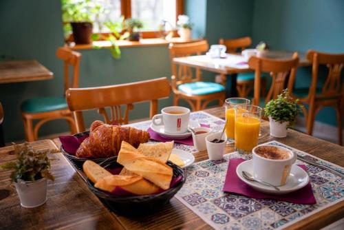 ein Tisch mit einem Frühstück aus Brot, Kaffee und Orangensaft in der Unterkunft L'Azimut in Senez