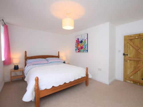 a bedroom with a bed and a wooden door at 2 Bed in Bideford oc-53994 in Appledore