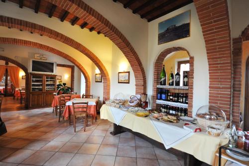 a restaurant with a table with food and bottles of wine at Albergo La Foresteria in Bettolle