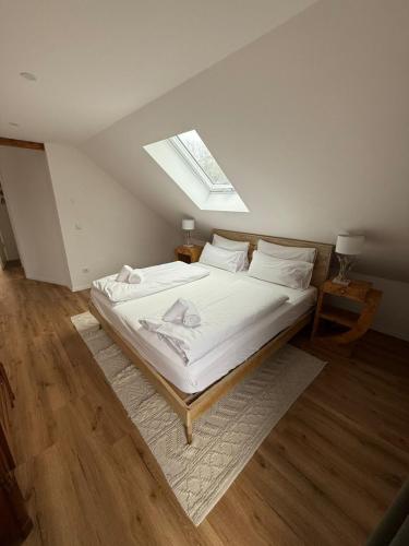a bedroom with a large bed with a skylight at ღLIBORIA I Loft am Riegsee in Aidling