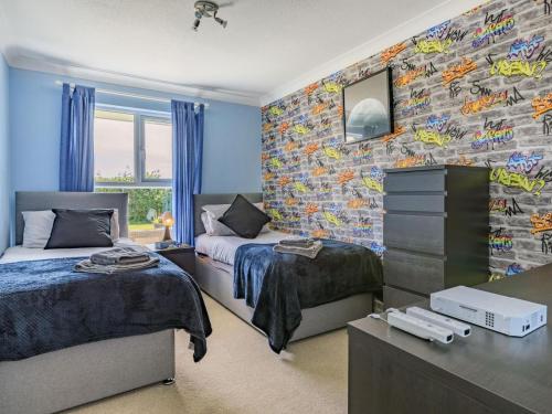 a bedroom with two beds and a wall covered in graffiti at 3 Bed in Braunton oc-87699 in Braunton