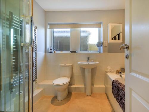 a bathroom with a toilet and a sink and a window at 3 Bed in Braunton oc-87699 in Braunton