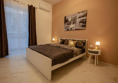 a bedroom with a bed in a room with a window at St Julians`s Charm Apartments in Is-Swieqi