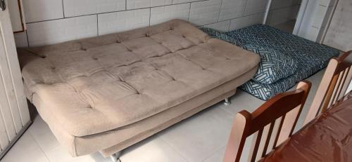 a brown couch in a room with two chairs at Casa reformada com Wi-Fi, garagem e lavanderia in Capão da Canoa