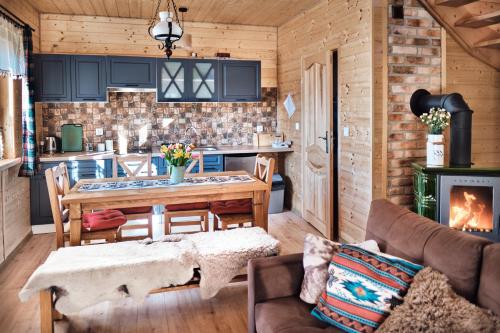 a kitchen and living room with a table and a stove at Domek Sol Wilcza Zagroda in Kudowa-Zdrój