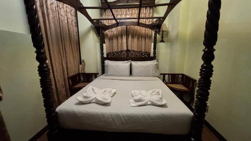 a bedroom with a bed with two towels on it at Casa Pichay in Vigan