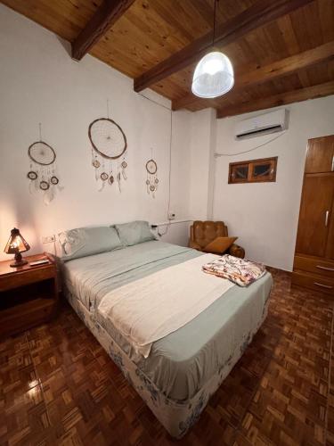 a bedroom with a large bed and a wooden floor at Raíces Vivas Selva Misionera in Oberá