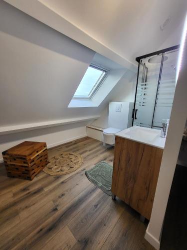 a attic bathroom with a sink and a window at L'escapade ansérienne in Oye-Plage