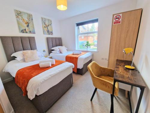 a bedroom with two beds and a table and a desk at Contractors 2 Bed Apartment in Stevenage By White Orchid Property Relocation in Stevenage