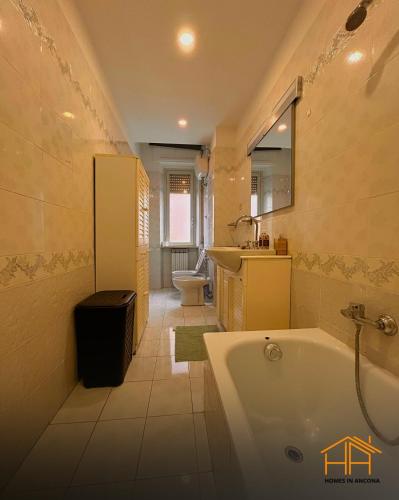 a bathroom with a tub and a sink and a toilet at VVR6 Apartment by Homes in Ancona in Ancona