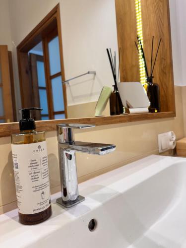 a bottle of soap sitting on a bathroom sink at Apartament Rynek 20 in Krosno