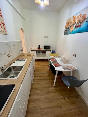a kitchen with a sink and a table with chairs at Saffi Rooms in Civitavecchia
