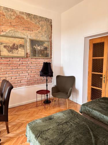 a bedroom with a brick wall and a chair at Apartament Rynek 20 in Krosno