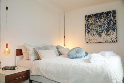 a bedroom with a white bed with a blue ball on it at Apartman Incerum in Požega