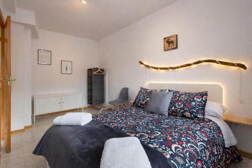 a bedroom with a bed and a chair at Treparriscos Home l Cine en casa l WIFI l Vistas in Biescas