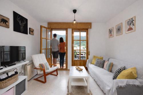 a couple looking out the door of a living room at Treparriscos Home l Cine en casa l WIFI l Vistas in Biescas