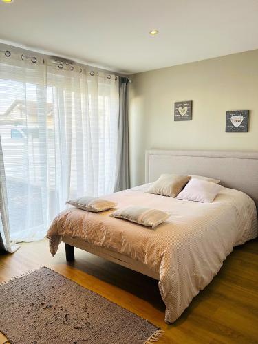a bed in a bedroom with a large window at La Perla in Mont-de-Marsan